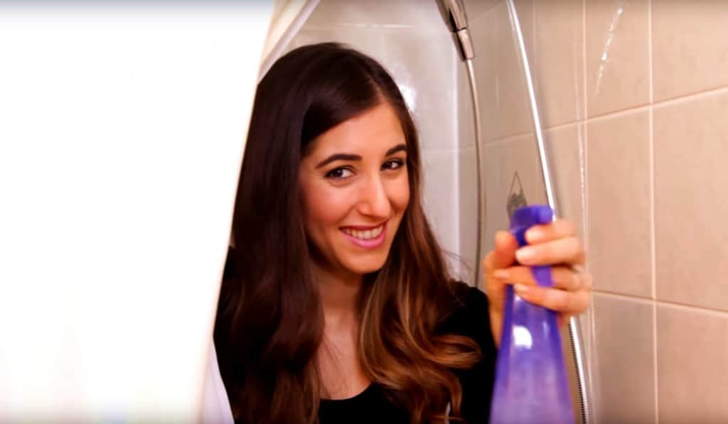 Melissa in the bathroom holding a spray bottle