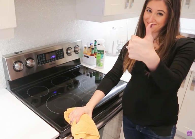Melissa is scrubbing a stove top with bac out