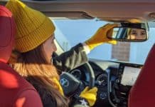 Car Interior Cleaning: The Ultimate Guide Melissa in her car looking into the mirror
