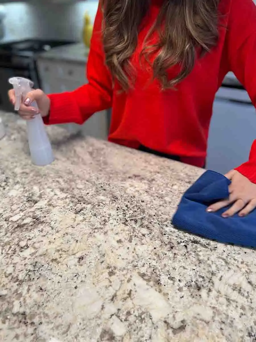 Cleaning a counter with spray bottle and microfiber cloth