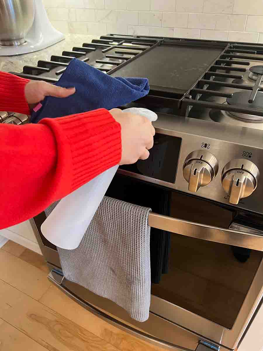 Cleaning the stove with a microfiber cloth