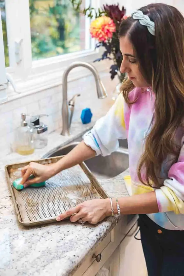 Melissa Maker scrubbing a pan with a sponge