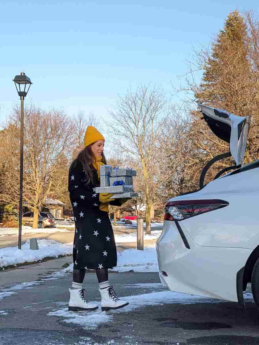 Melissa loading presents into her car. 