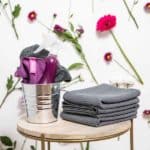 The Best Spring Cleaning Checklist cleaning supplies against a wall with flowers