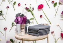 The Best Spring Cleaning Checklist cleaning supplies against a wall with flowers