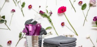The Best Spring Cleaning Checklist cleaning supplies against a wall with flowers